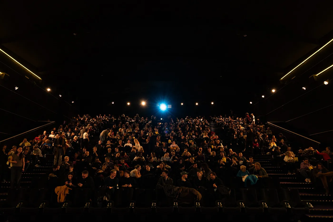 Wide view across a packed auditorium towards the screen