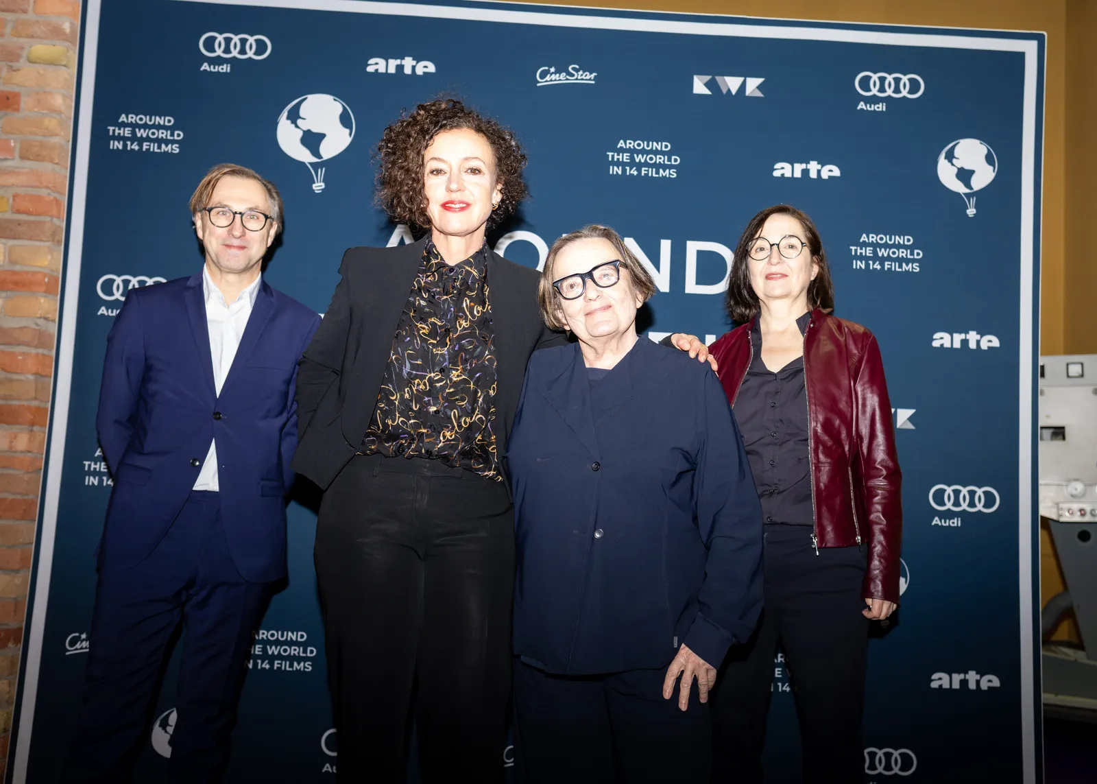 Maria Schrader und Agnieszka Holland mit zwei Begleitern vor der Fotowand des Festivals.