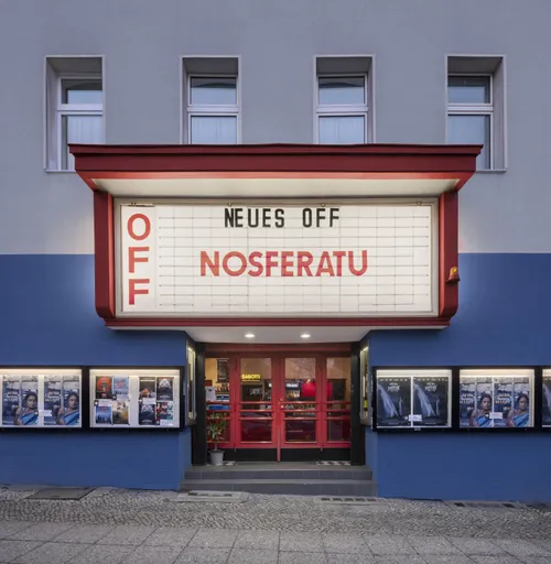 The façade of the Neues Off with its illuminated lettering at night